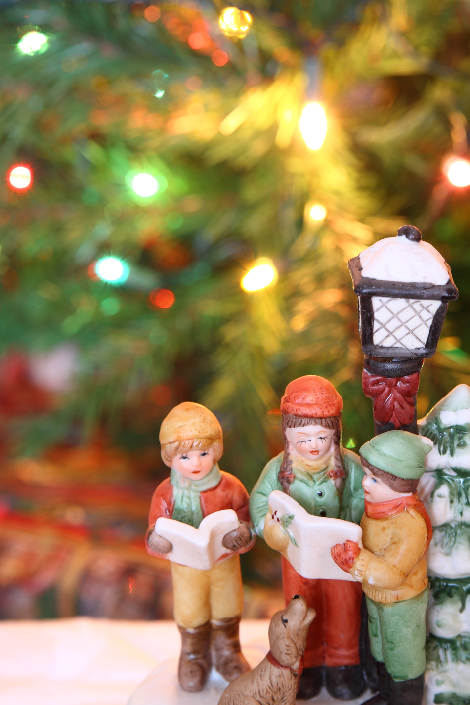 Christmas carolers figurines over a Christmas background
